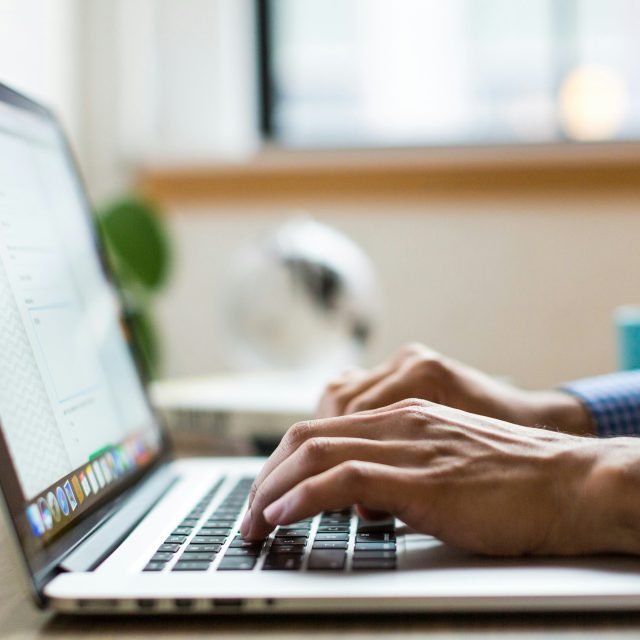 man typing on laptop computer